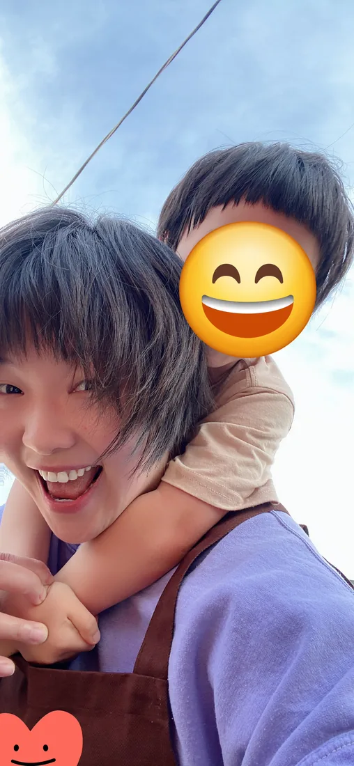 Lia laughing with a preschooler on her shoulders outdoors during her years working in early childhood education